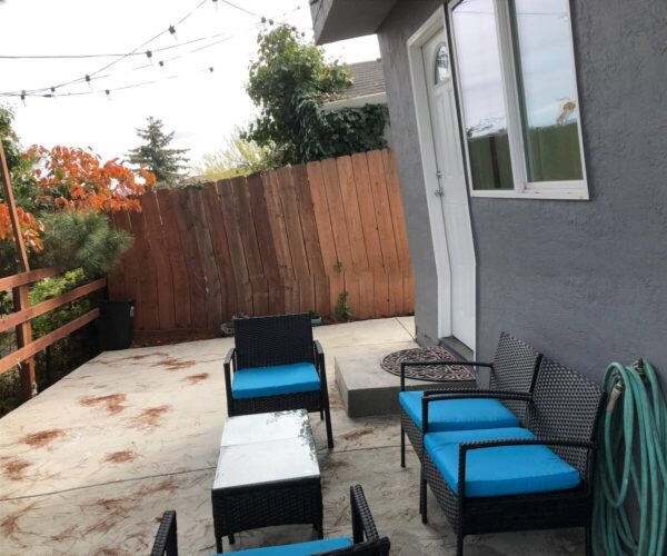 A patio with blue chairs and tables outside