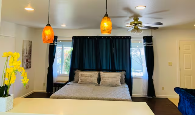 A bedroom with two lights hanging above the bed.