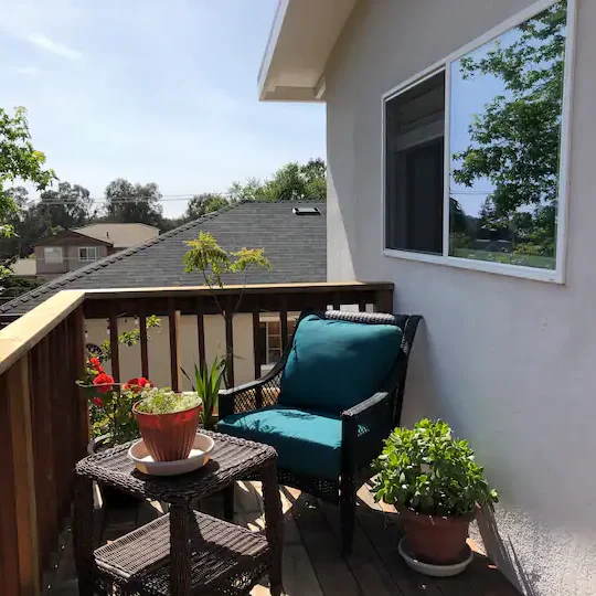 A small balcony with a chair and table