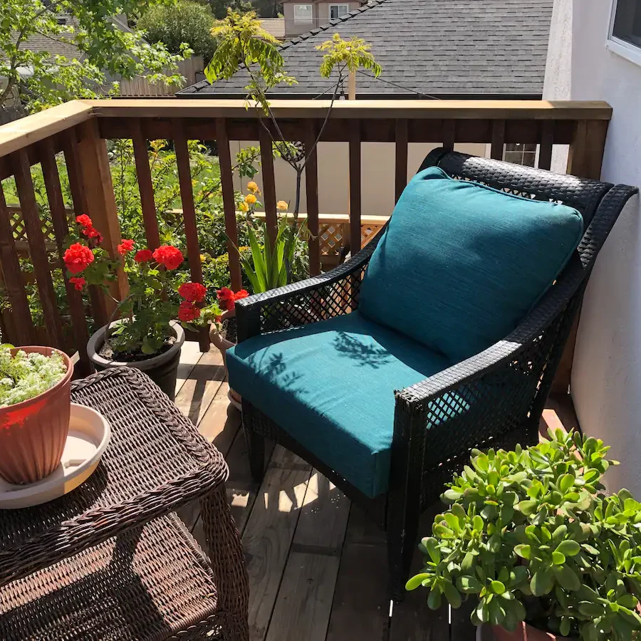 A blue chair on the back porch of a house.