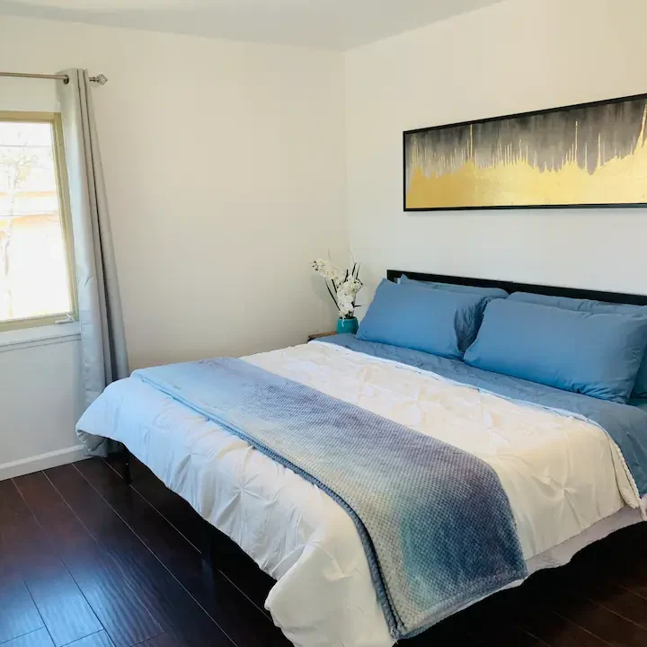 A bedroom with a large bed and wooden floors